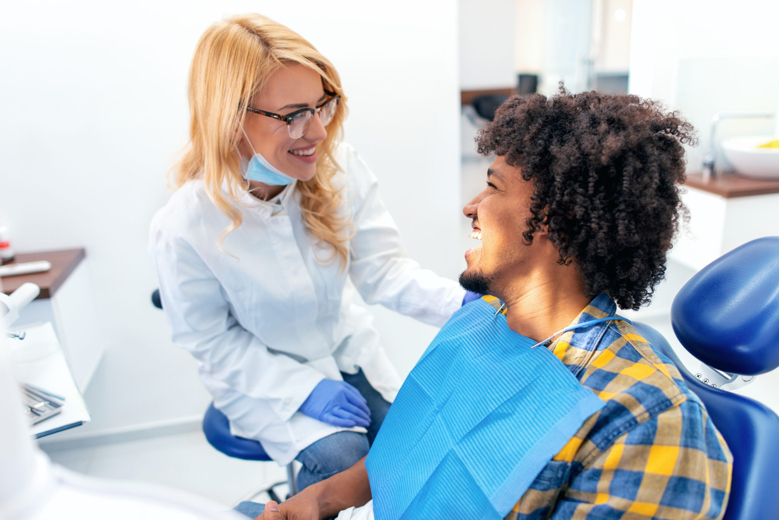 Dentist talking to male patient in clinic